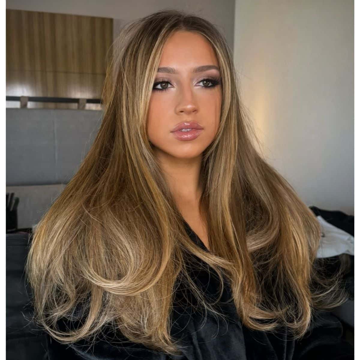 Tate McRae with long, honey-blonde hair styled in smooth, blended layers with face-framing volume.