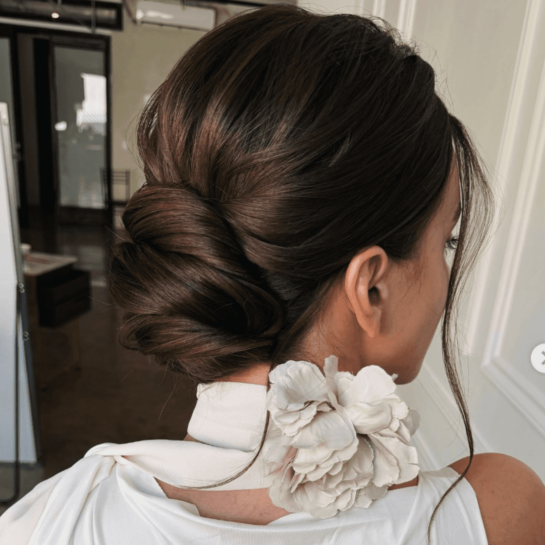 Soft, low chignon hairstyle with loose face-framing pieces and natural texture