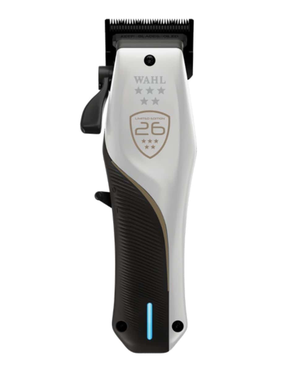 Studio product shot of the limited-edition Wahl® Professional 5 Star Vapor® CE cordless clipper featuring a white and black ergonomic body, blue LED indicator light and championship-inspired gold detailing.