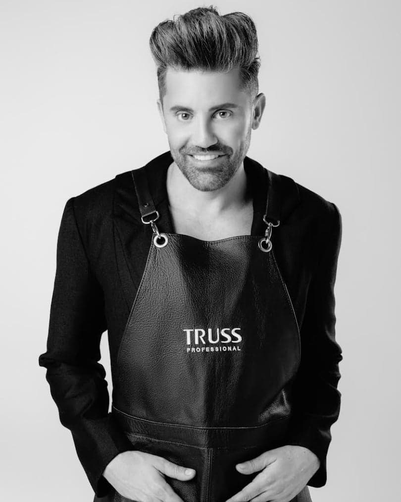 Gabriel Samra as Global Ambassador and Director of Stage Mastery for Truss Professional standing in truss hairstylist apron smiling