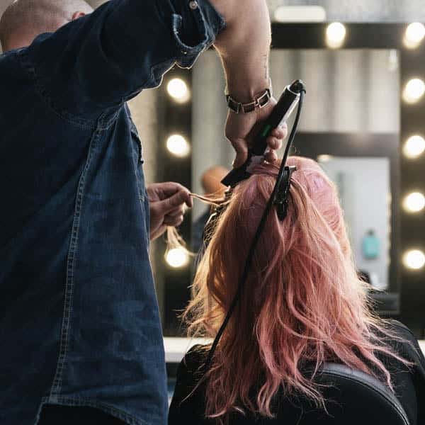Women Getting Hair Curled Stock