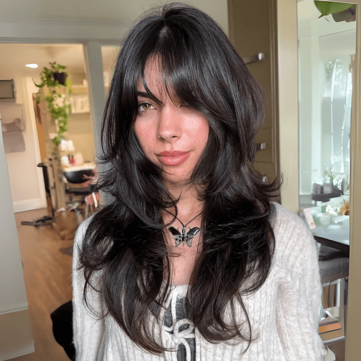 woman with glossy long black hair layered wolf cut
