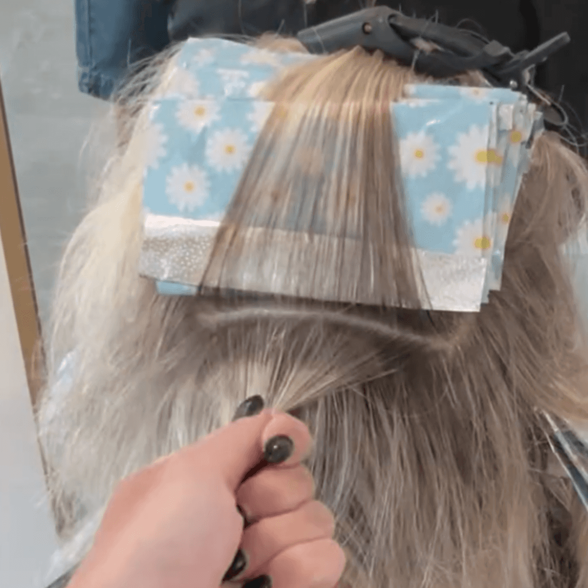 leaving a section of hair pinned to the top of foils with another ready to be colored
