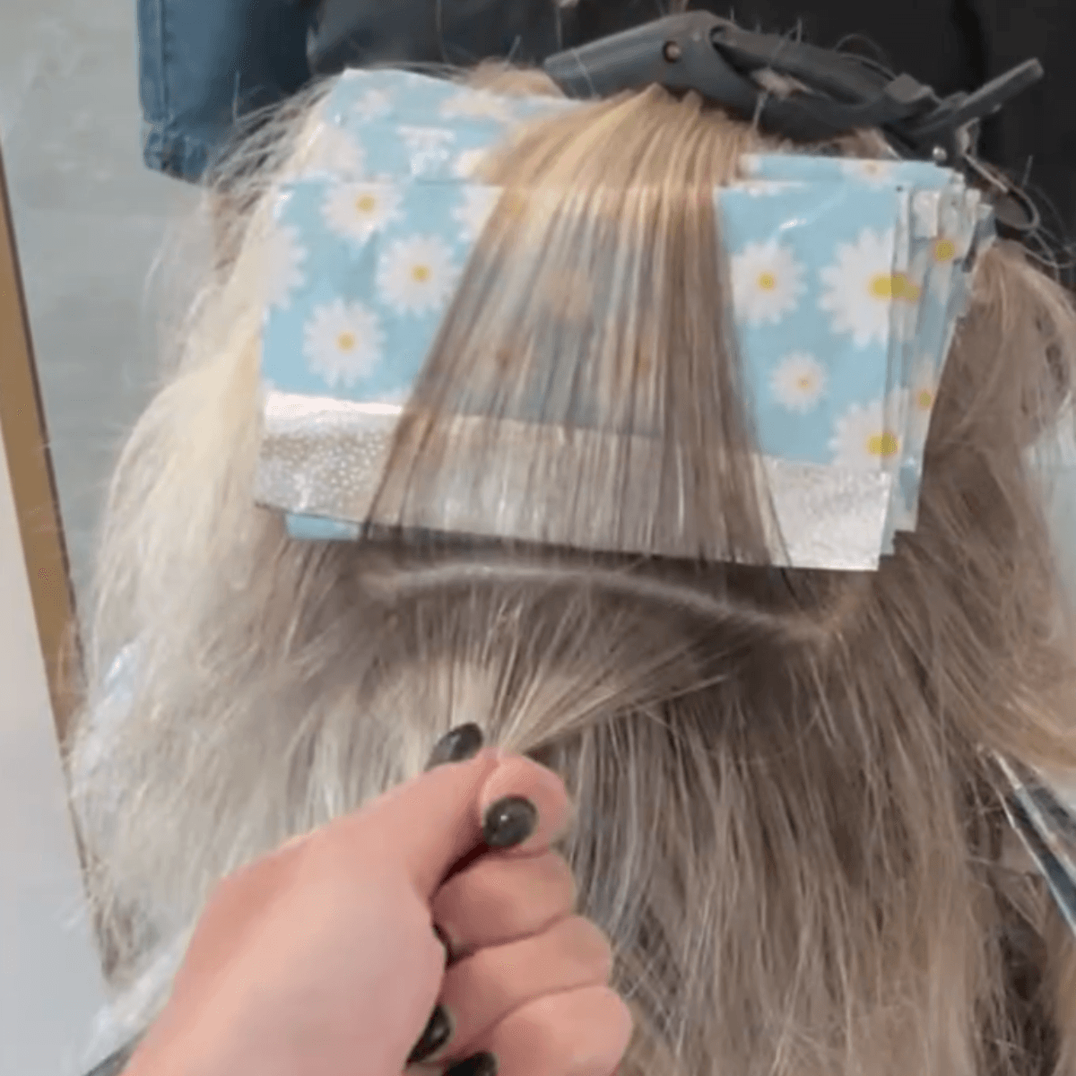 leaving a section of hair pinned to the top of foils with another ready to be colored
