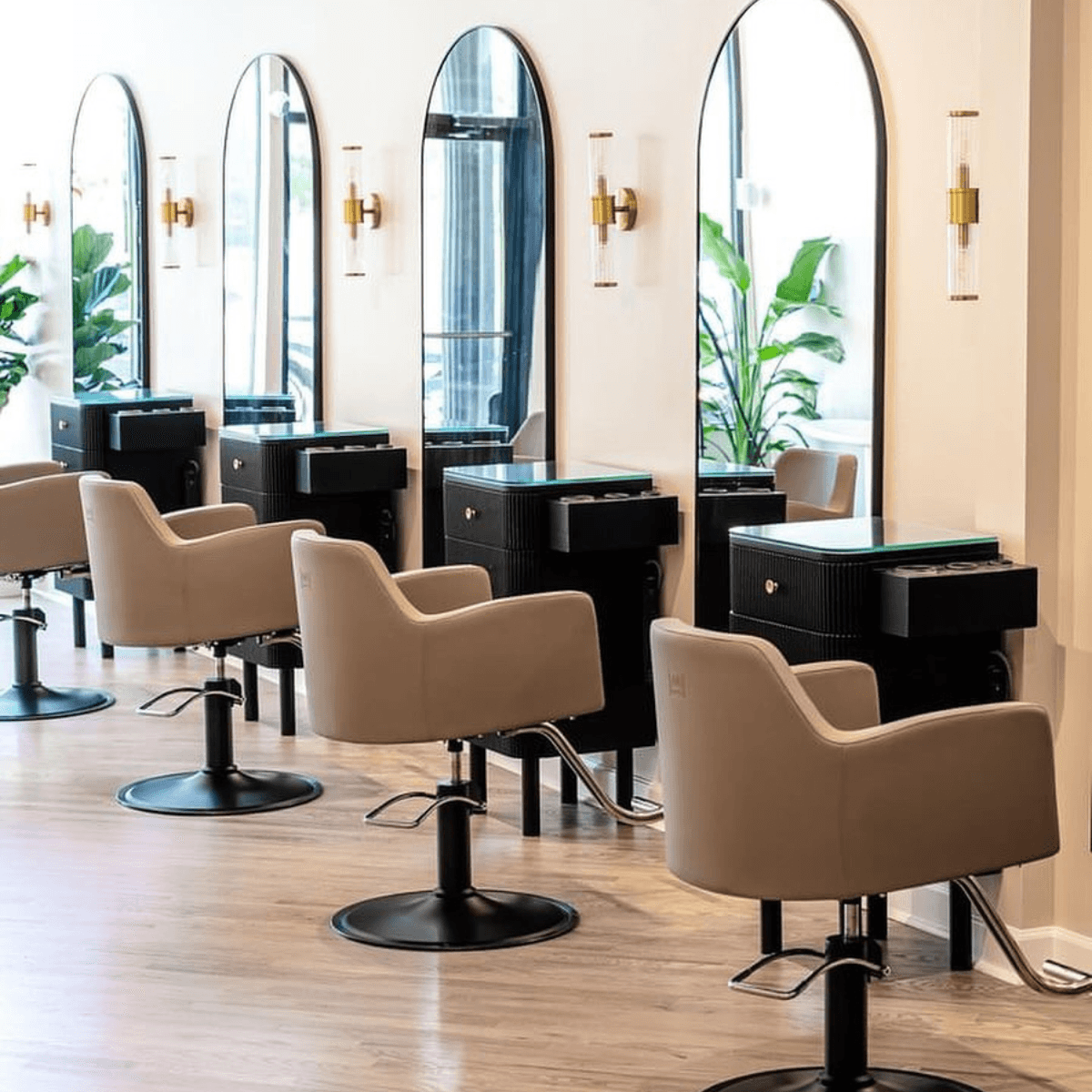 beige salon chairs and black framed mirrors at 4 stations