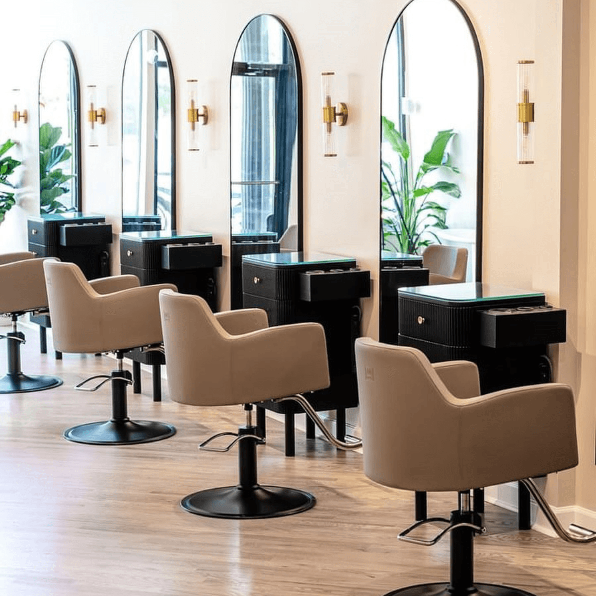 beige salon chairs and black framed mirrors at 4 stations