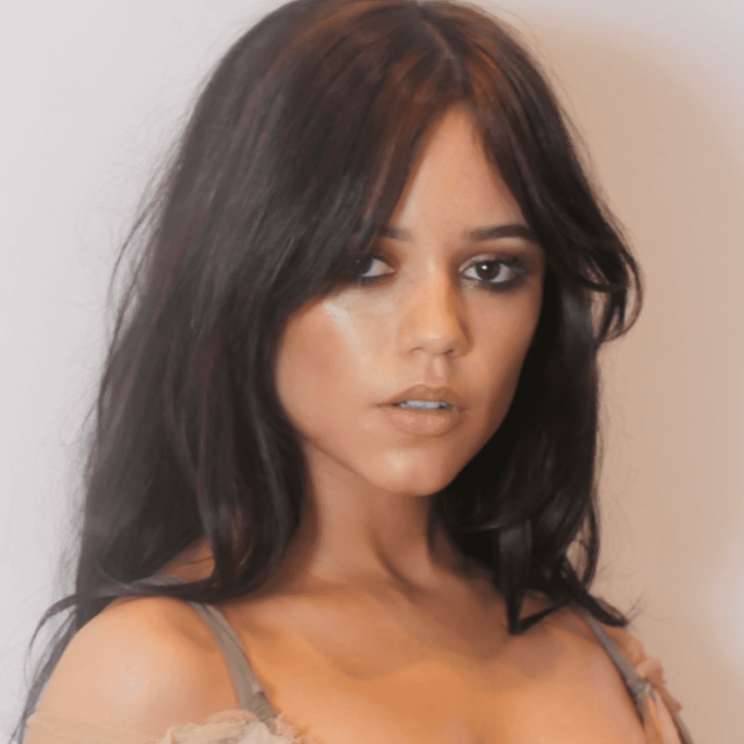Jenna Ortega’s 2025 Oscars hair features soft, tousled waves with a center part, face-framing layers, and a sheer off-the-shoulder dress.