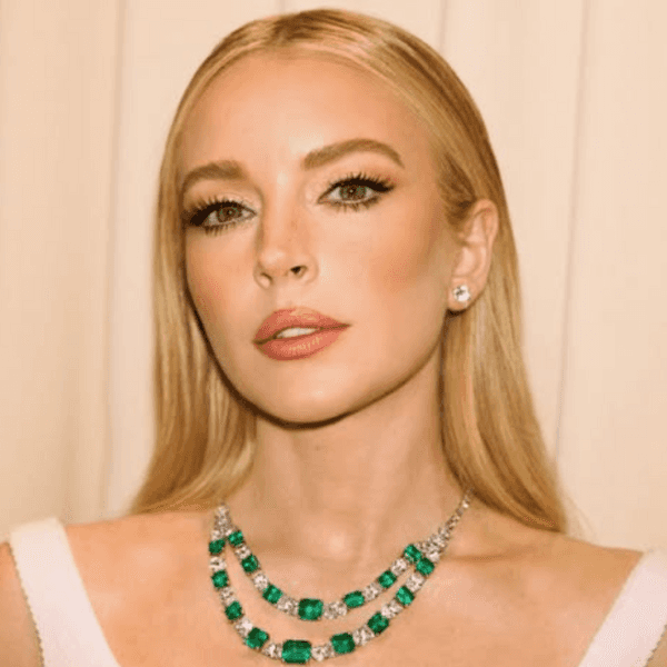 Lindsay Lohan at the 2025 Vanity Fair Oscars Party with sleek, soft waves in a white dress on the red carpet.