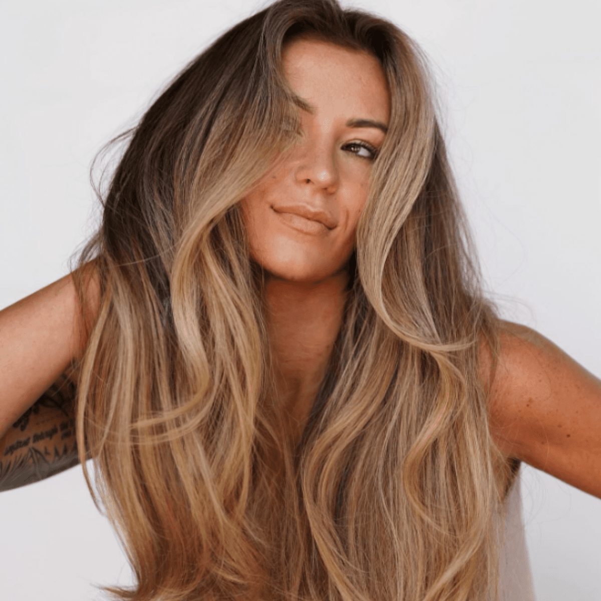 Sun-kissed bronde with a natural root melt and soft, beachy waves.