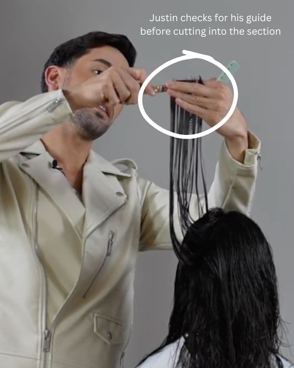 Stylist checks the guide before cutting into a vertical section to avoid creating holes in long layered hair.